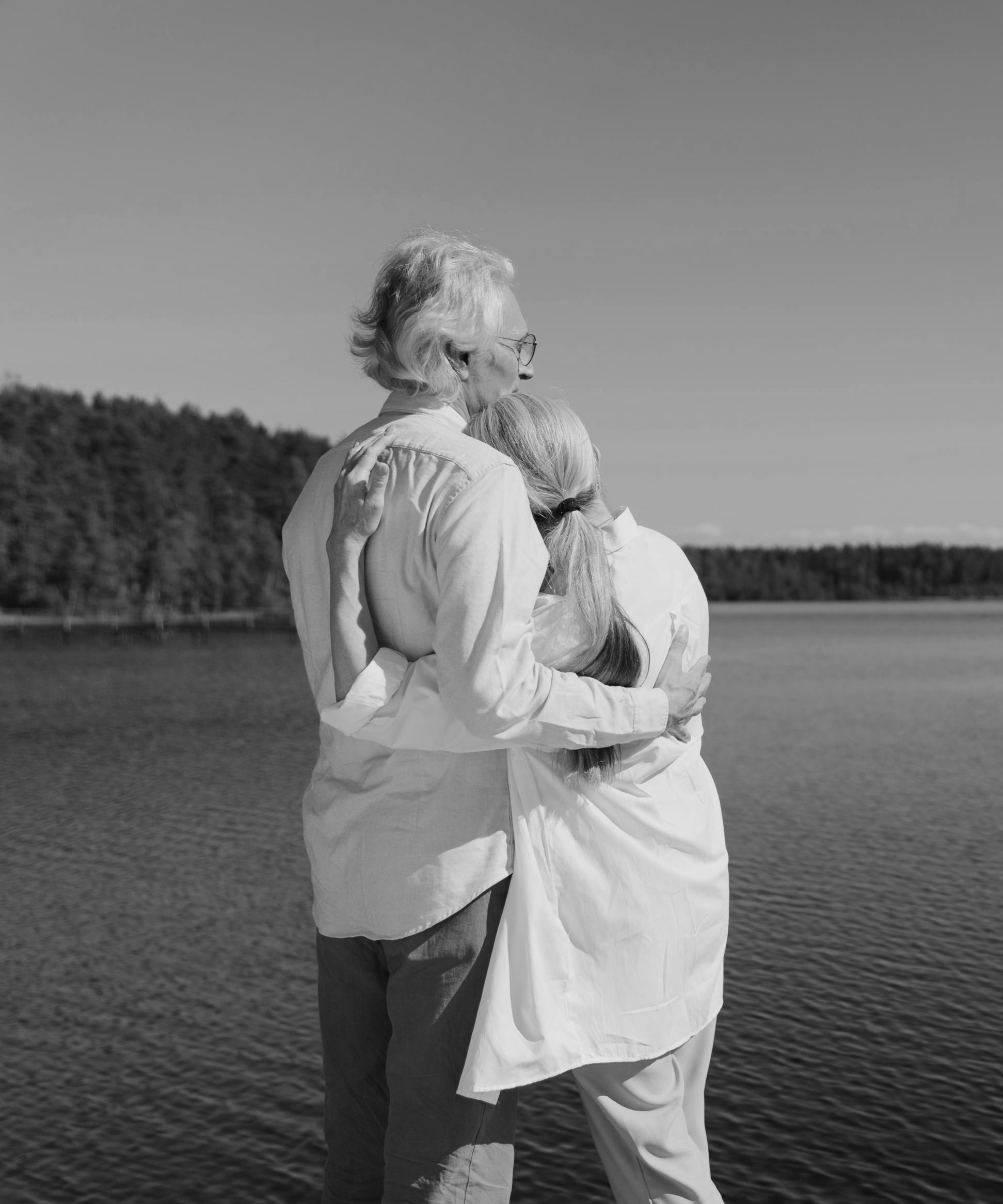 elderly couple standing by the lake