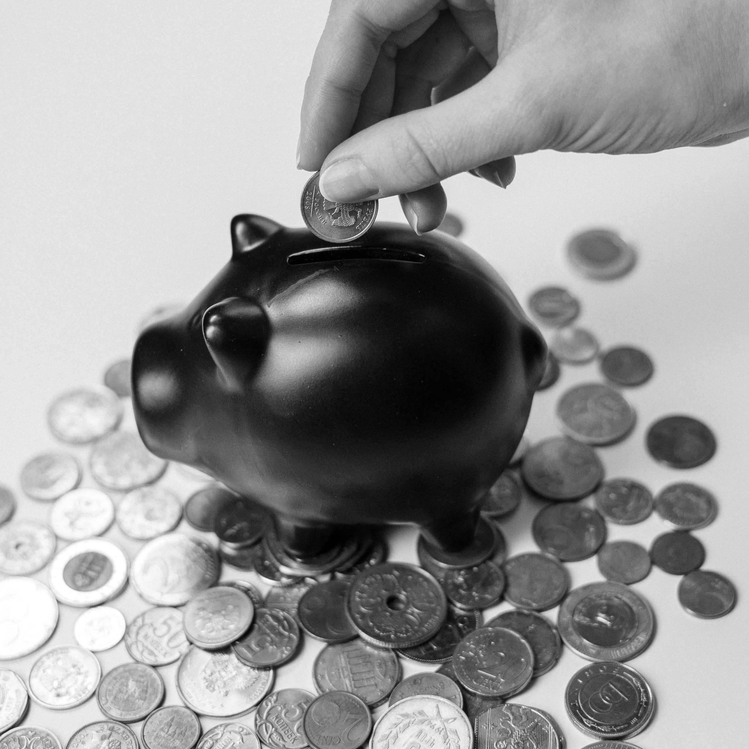 adding coins to a small piggy bank
